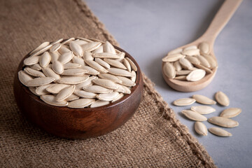 A bowl with spoon full of pumpkin seeds,top view