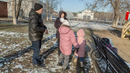 Grandparents with granddaughters playing in the park on a sunny winter day