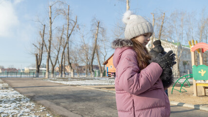little girl playing on the playground on a winter day