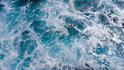 ocean surface foaming from waves, texture and shape of sea water, aerial view