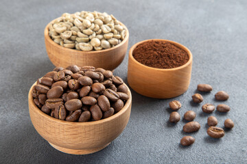Green coffee with roasted coffee beans on gray background