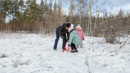 Little girls with her grandfather walk in a snowy forest, have fun together