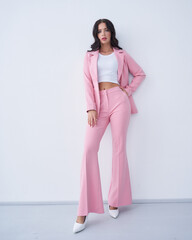 Stylish woman in pink suit posing confidently