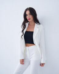 Stylish woman in white suit posing confidently