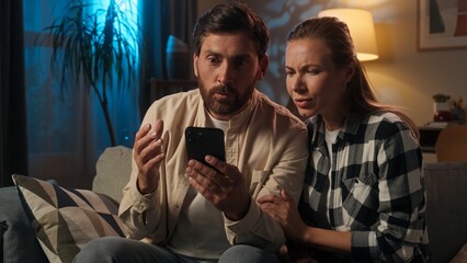 Affectionate couple husband wife Caucasian happy family woman man buyers homeowners girl guy discuss choosing purchase mobile phone buying online shopping repair home evening talking order smartphone