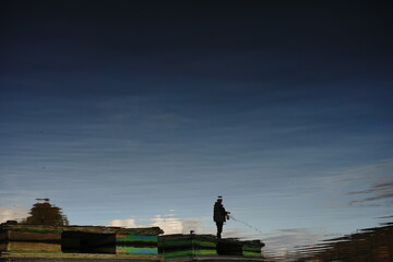 reflection of a fisherman on the lake
