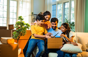 Asian family excitedly unboxes belongings together in their new home while sharing joyful moments