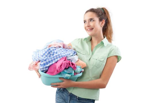 Smiling woman holding plastic laundry basket filled with dirty laundry, isolated on white background. Concept of household chores, laundry day, domestic work and clothing care or Laundry services