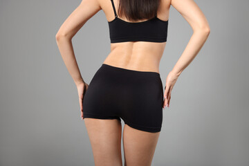 Woman with perfect slim body on gray background, closeup