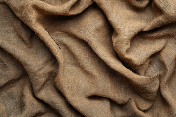 Close-up of textured fabric resembling linen or burlap showcasing natural fibers and earthy tones