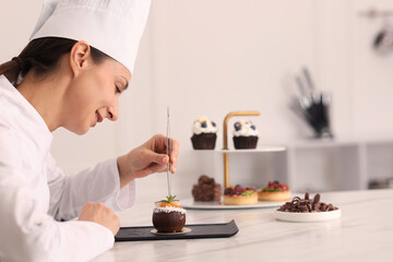 Confectioner making delicious coconut shaped dessert at table