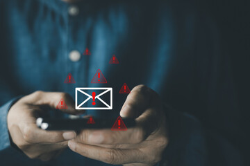 Businessman receives suspicious email alert that may be spam email, warning email icons, malware,...