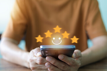 Customer satisfaction and online feedback. A person's hands holding a smartphone, with a digital...