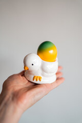 A colorful Easter egg resting in a simple stand, symbol of rebirth and celebration. Painted with colorfull paints, it adds a festive touch to spring traditions and holiday tables