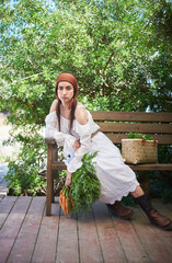 portrait of young woman with dark hair in white dress on farm in summer