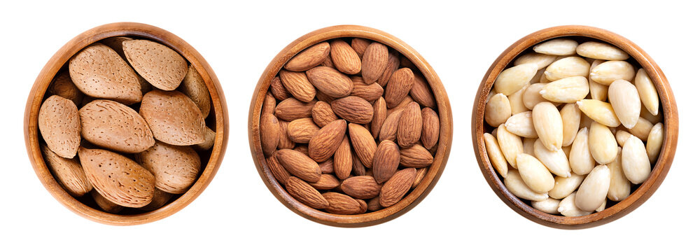 Almonds in shell, shelled and skinless, in wooden bowls. On the left side unshelled almonds, in the center with their shell removed, but still with brown seed coats, and blanched on the right side.