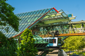 Eine Schwebebahn fährt aus der Haltestelle Kluse, Wuppertal, Deutschland
