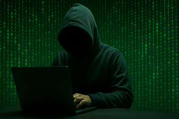 Anonymous Hacker in Dark Hoodie Using Laptop with Binary Code Background &mdash; Cybersecurity Threat, Data Breach, and Digital Crime Concept