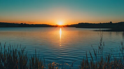 Fototapeta premium Sunset over tranquil water, a serene nature scene with a wide viewpoint, capturing the calm and aesthetic environment.