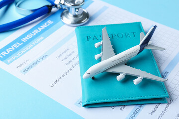 Medical tourism. Travel insurance application form, stethoscope, passport and plane model on light...