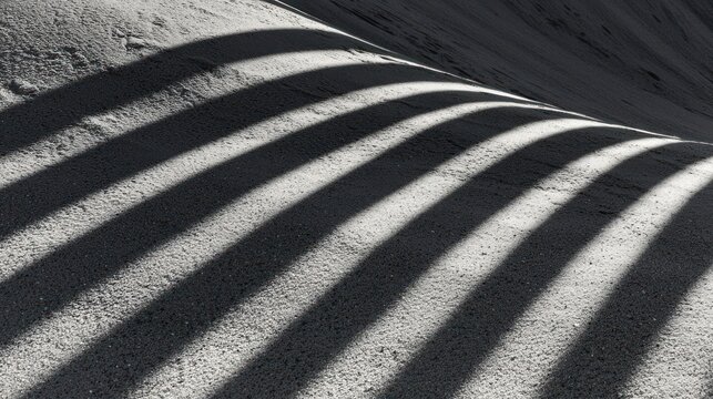 Abstract pattern of long, parallel shadows on a textured surface.