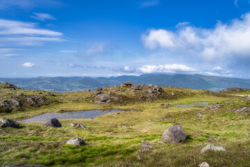 This stunning view showcases a breathtaking mountainous region filled with vibrant green grass, striking rocky formations, and a beautifully picturesque sky above, Carlingford, Ireland