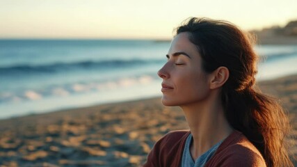 A woman sits on a beach, gazing out at the vast ocean