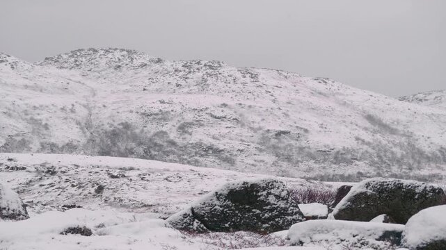 Breathtaking drone footage of Hartsop Dodd mountain during winter in the Lake District, England, showing snow-blanketed hills and tranquil natural scenery.