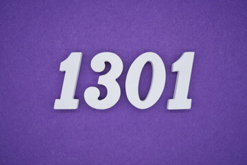 The numbers are made of white painted wood placed on a purple paper background.