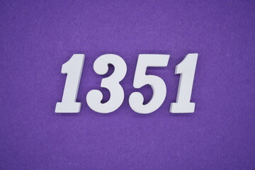 The numbers are made of white painted wood placed on a purple paper background.