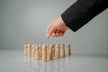 Hand Choosing Wooden Figures on Surface for Business Decision Making