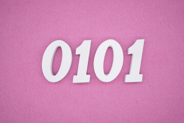The numbers are made of white painted wood, placed on a pink paper background.