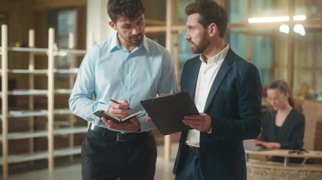 Caucasian businessmen men co-workers business partners professional colleagues talk in office discuss documents deal contract in office male guys employees boss assistant writing notes consultation