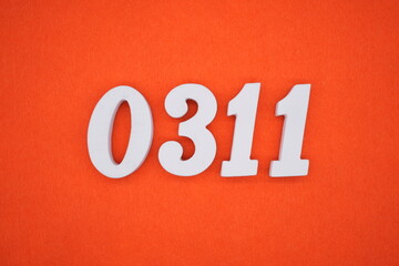 The numbers are made of white painted wood placed on an orange paper background.
