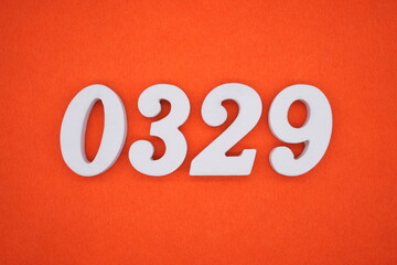 The numbers are made of white painted wood placed on an orange paper background.