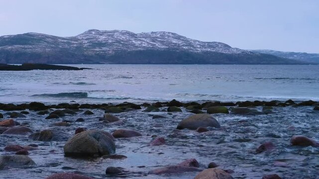 Footage capturing the rugged rocky coastline of the Barents Sea marginal sea, highlighting the remote Arctic coastal environment of Norway and Russia.