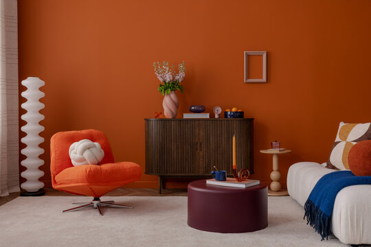 Retro-inspired living room with orange accent wall, soft white seating, sculptural decor, and pastel accessories. A playful and sophisticated interior setup.