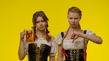 Two women in traditional dress with mixed emotions and beer