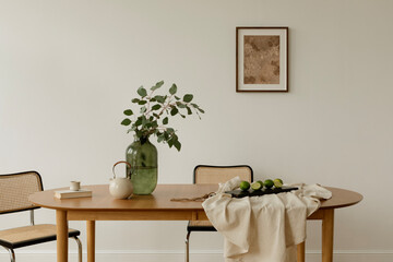 Bright interior with minimalist setup, a dining table styled with greenery, teapot, and limes on neutral linen. Scandinavian and Japanese design influences.