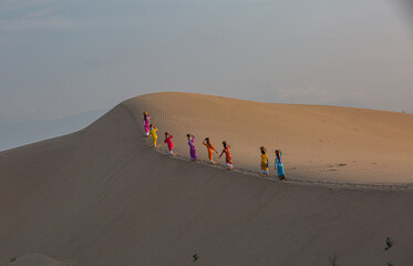 Cham women cross sand dunes on their way to work. Photo taken in Phan Rang on May 4, 2018.