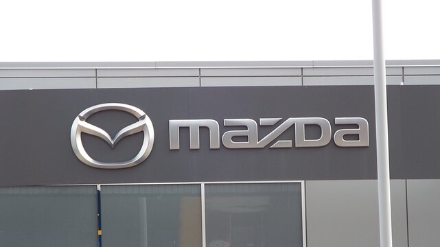 Ottawa, ON, Canada-May 15,2025:  A "Silver Mazda Logo" and lettering prominently displayed on a dark building at 1638 Carling Avenue.
