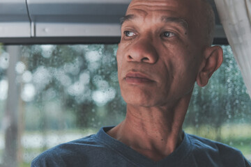Close-up of a sad asian senior man with lonely alone on a rainy day and thinking about something, Elderly health concept, depression and mental health, World Senior Citizen's Day.