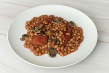 Baked beans in a rich tomato sauce with canned tomatoes and fried mushrooms.
