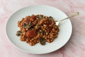 Baked beans in a rich tomato sauce with canned tomatoes and fried mushrooms.