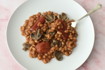 Baked beans in a rich tomato sauce with canned tomatoes and fried mushrooms.