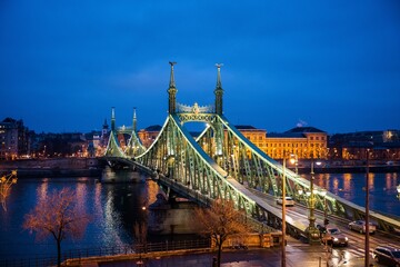Obraz premium Budapest, Hungary - January 22 2023: Liberty Bridge (Szabadság híd) illuminated at dusk, spanning the Danube River in central Budapest.