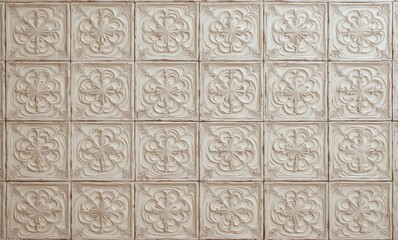 Intricate decorative wall tiles featuring floral patterns in soft beige tones.