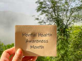 Mental Health Awareness Concept - mental health awareness month text on paper with nature...