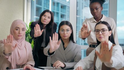 Strong serious multiethnic women females team girls African American Caucasian Japanese Muslim hijab Arabian businesswomen looking camera showing palm gesture no deny refuse stop office meeting room