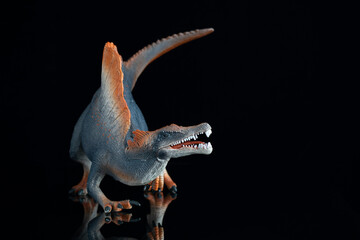 Spinosaurus figurine on black background